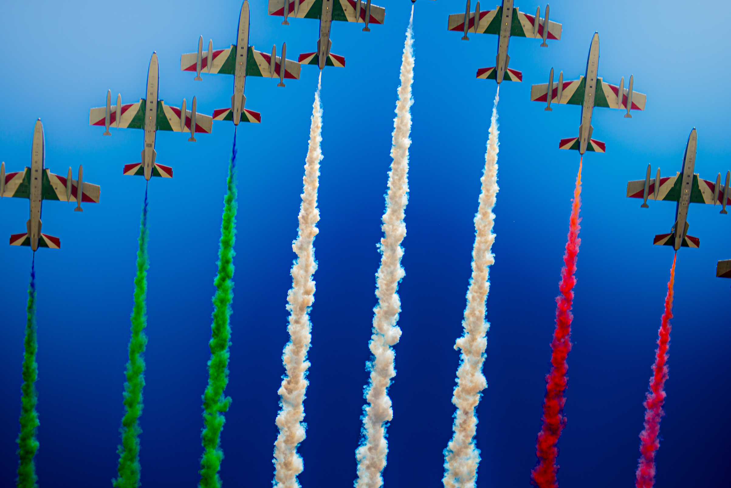The Italian Frecce Tricolori aviation display team emitting a sequence of equally spaced jets of smoke. As the jet flow loses energy and begins to mix with the free stream flow, the scales of turbulent mixing can be seen.
